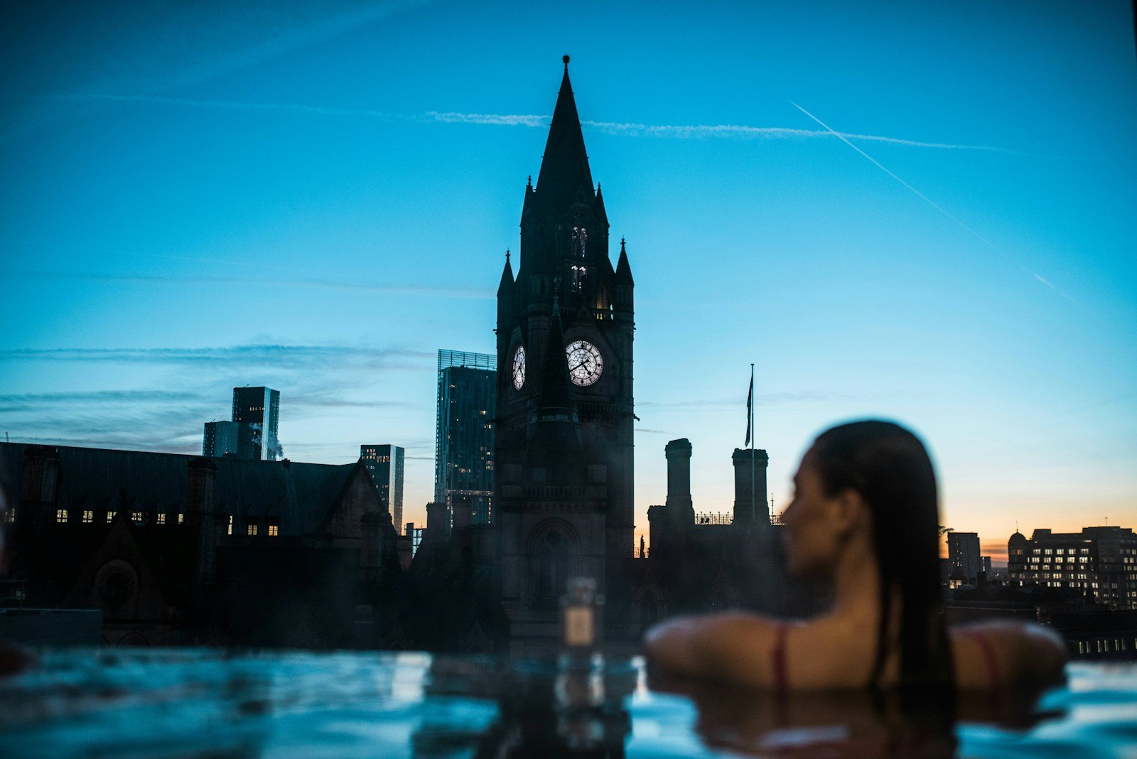 a woman in a hot tub with a clock tower in the background